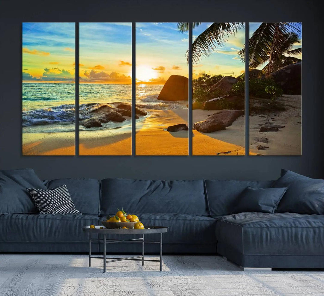 The Serene Tropical Beach Sunset Canvas Wall Art, a 3-panel giclee print, beautifully captures an ocean sunset with its depiction of palm trees and a coastal rock formation.