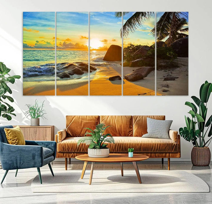 The Serene Tropical Beach Sunset Canvas Wall Art, a 3-panel giclee print, beautifully captures an ocean sunset with its depiction of palm trees and a coastal rock formation.