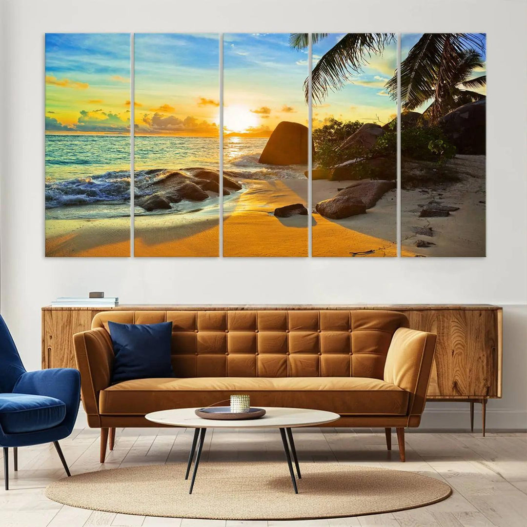 The Serene Tropical Beach Sunset Canvas Wall Art, a 3-panel giclee print, beautifully captures an ocean sunset with its depiction of palm trees and a coastal rock formation.