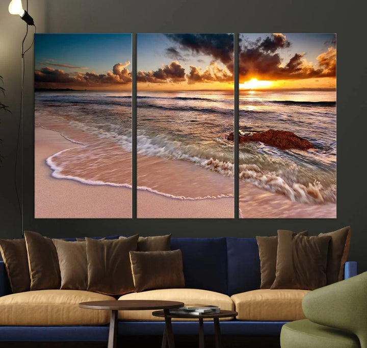 The Sunset Beach Waves Triptych Wall Art, featuring a tropical ocean scene on giclee canvas with a gallery wrap, adorns the wall in a cozy, coastal-themed living room.