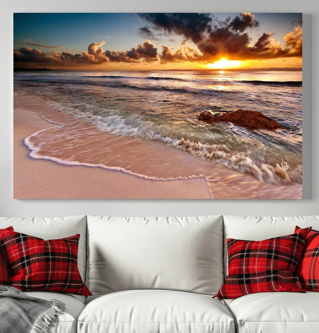 The Sunset Beach Waves Triptych Wall Art, featuring a tropical ocean scene on giclee canvas with a gallery wrap, adorns the wall in a cozy, coastal-themed living room.