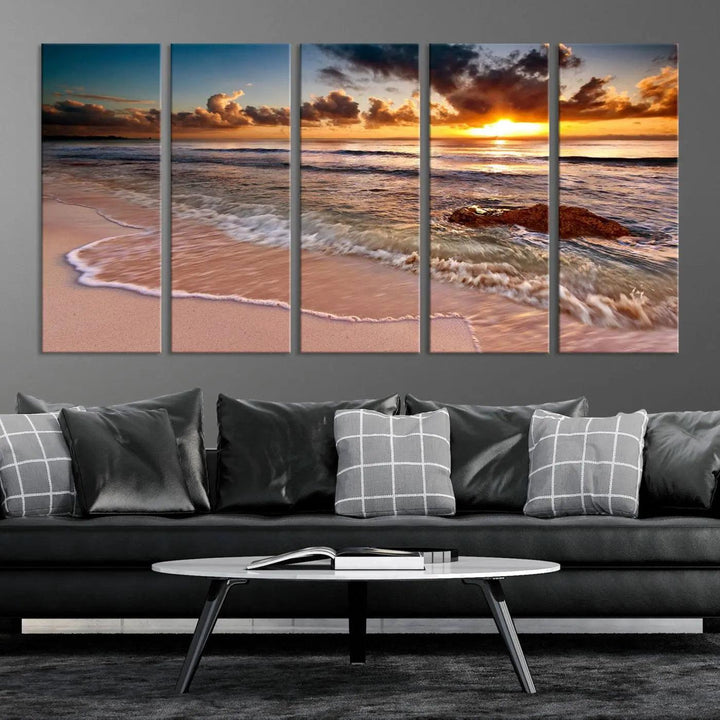 The Sunset Beach Waves Triptych Wall Art, featuring a tropical ocean scene on giclee canvas with a gallery wrap, adorns the wall in a cozy, coastal-themed living room.