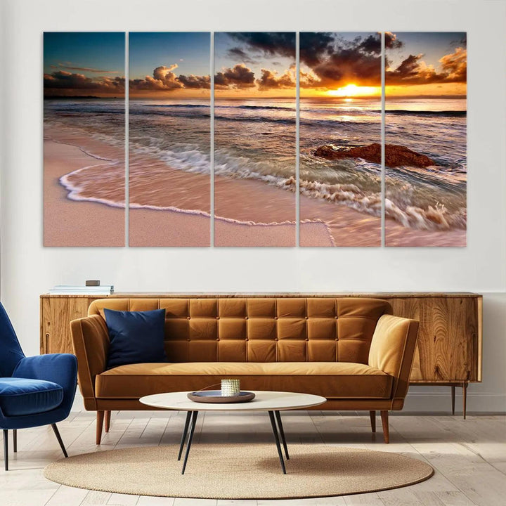 The Sunset Beach Waves Triptych Wall Art, featuring a tropical ocean scene on giclee canvas with a gallery wrap, adorns the wall in a cozy, coastal-themed living room.