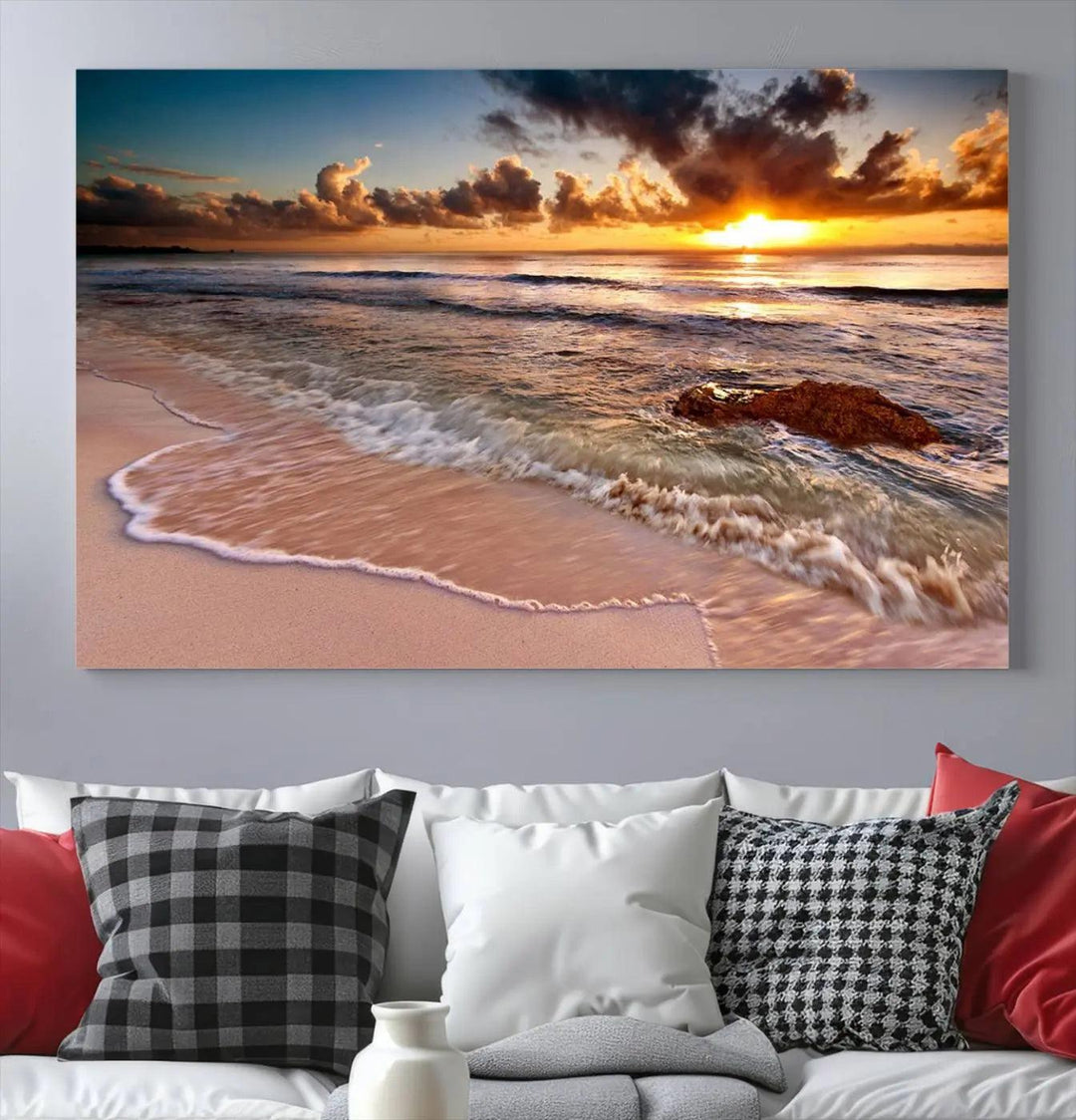 The Sunset Beach Waves Triptych Wall Art, featuring a tropical ocean scene on giclee canvas with a gallery wrap, adorns the wall in a cozy, coastal-themed living room.