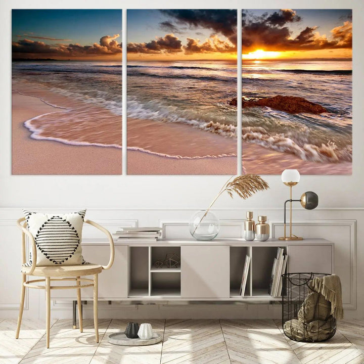 The Sunset Beach Waves Triptych Wall Art, featuring a tropical ocean scene on giclee canvas with a gallery wrap, adorns the wall in a cozy, coastal-themed living room.