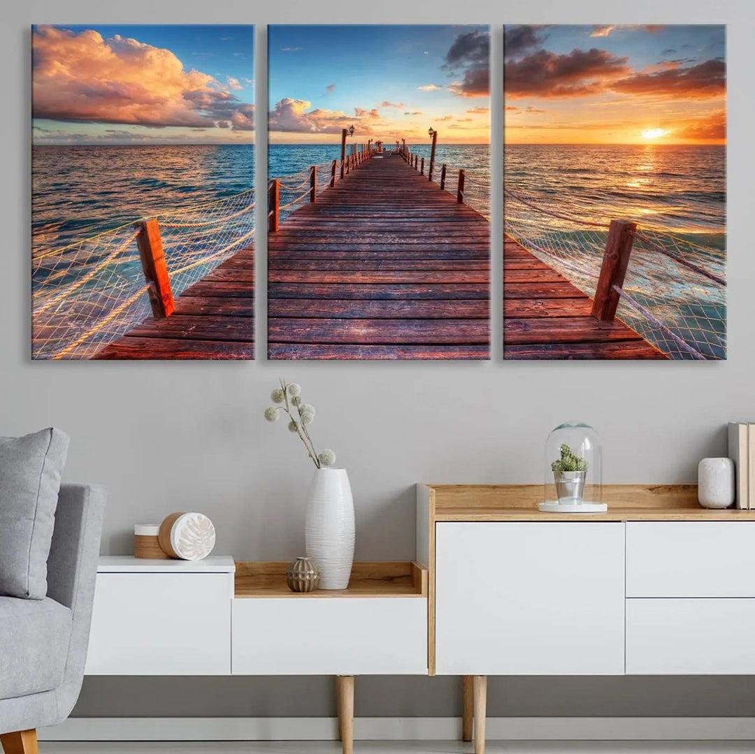 The Sunset Pier Canvas Wall Art is a triptych featuring an ocean landscape that elegantly captures a tranquil beach sunset with gentle ocean waves. It comes beautifully framed and ready to hang.