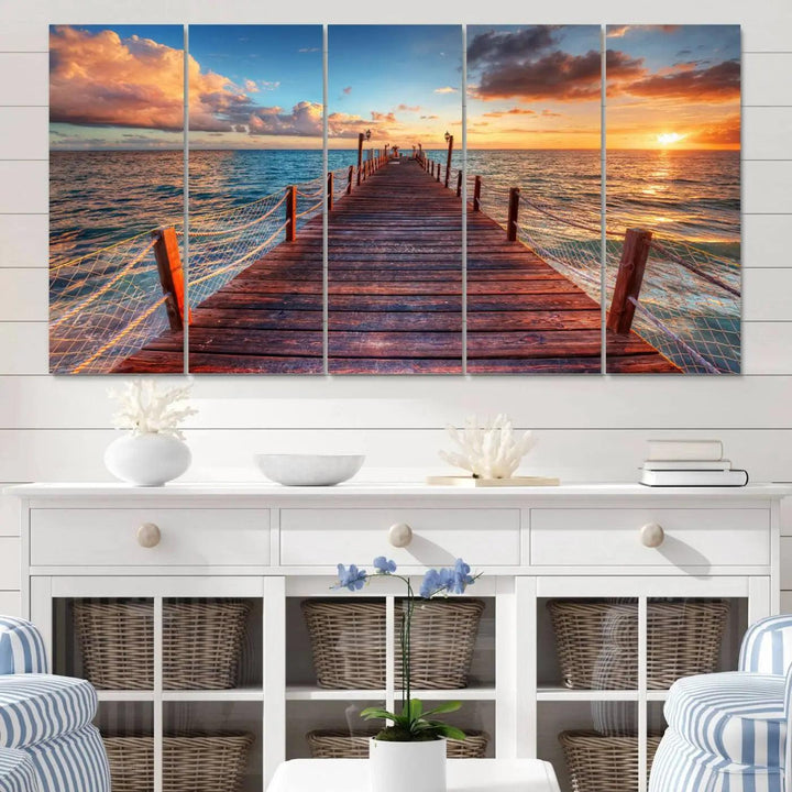 The Sunset Pier Canvas Wall Art is a triptych featuring an ocean landscape that elegantly captures a tranquil beach sunset with gentle ocean waves. It comes beautifully framed and ready to hang.