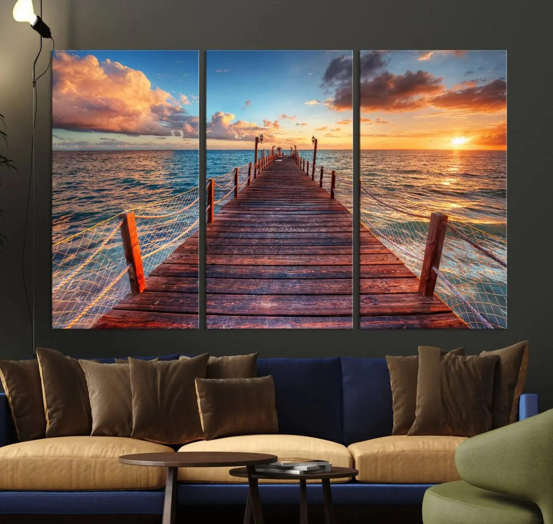 The Sunset Pier Canvas Wall Art is a triptych featuring an ocean landscape that elegantly captures a tranquil beach sunset with gentle ocean waves. It comes beautifully framed and ready to hang.