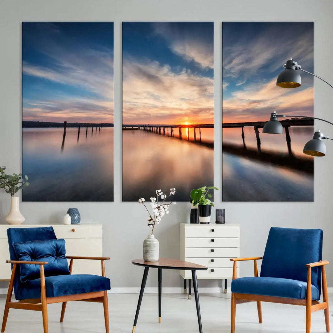 The tranquil sunset casting its glow over a peaceful lake with a long wooden pier captures the essence of coastal allure. The soft clouds mirrored in the water beautifully evoke the ambiance provided by the Sunset Pier Giclee Canvas Wall Art, a masterpiece designed for modern home decor and reminiscent of minimalist art.