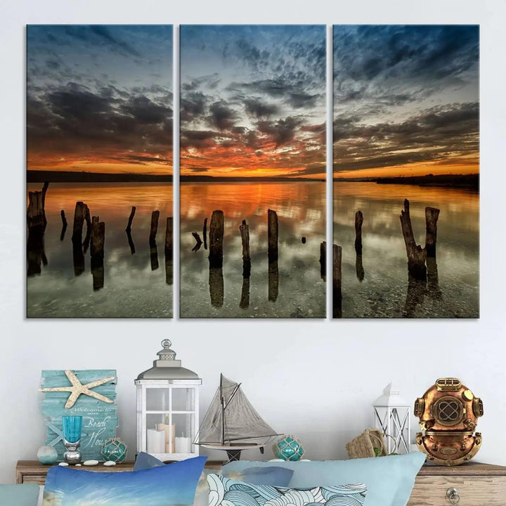 The "Sunset Reflection on Wooden Pier Giclee Canvas Print" is a panoramic wall art piece showcasing serene nature photography with a colorful sunset over water and wooden posts.