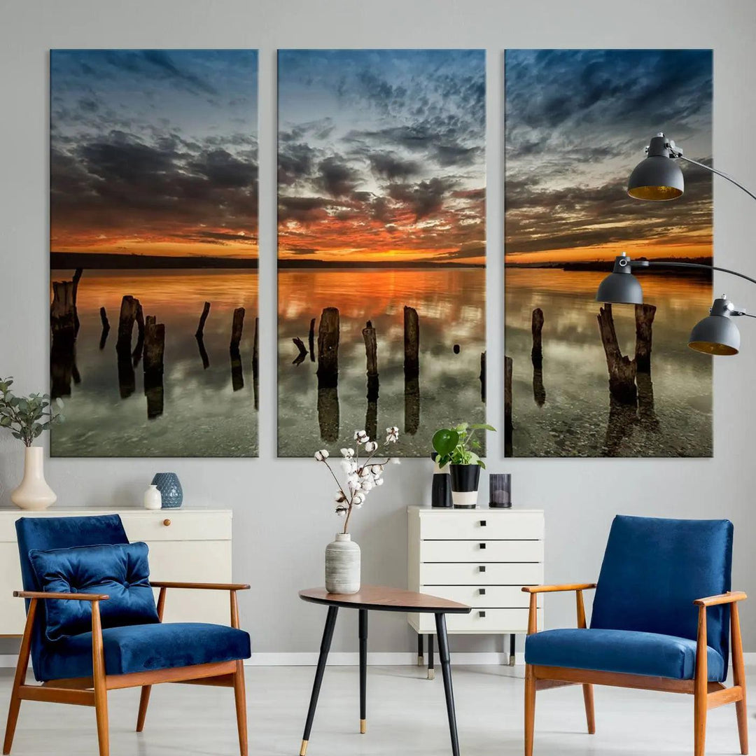 The "Sunset Reflection on Wooden Pier Giclee Canvas Print" is a panoramic wall art piece showcasing serene nature photography with a colorful sunset over water and wooden posts.