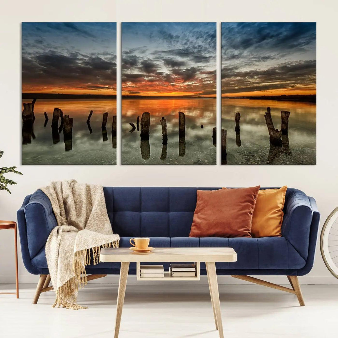 The "Sunset Reflection on Wooden Pier Giclee Canvas Print" is a panoramic wall art piece showcasing serene nature photography with a colorful sunset over water and wooden posts.