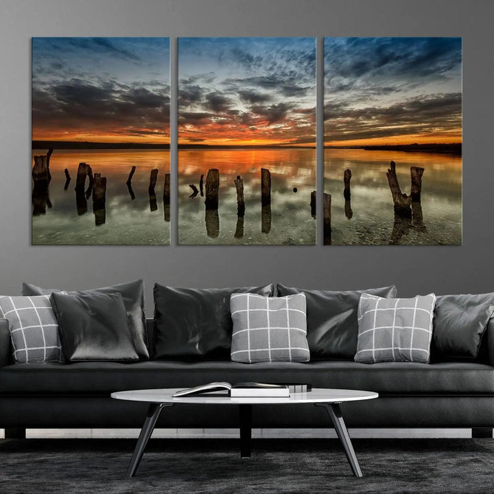 The "Sunset Reflection on Wooden Pier Giclee Canvas Print" is a panoramic wall art piece showcasing serene nature photography with a colorful sunset over water and wooden posts.