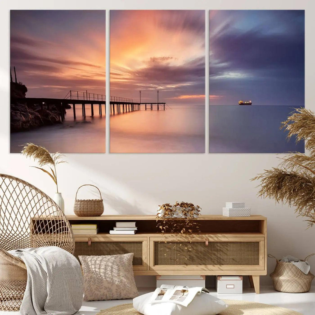 The Sunset Serenity Pier Canvas Art, a giclee canvas print with gallery wrap, beautifully captures a triptych of tranquility as the sun sets over calm waters. Featuring a pier on the left and a ship on the horizon, it adds an elegant touch to any living space with its serene coastal decor.