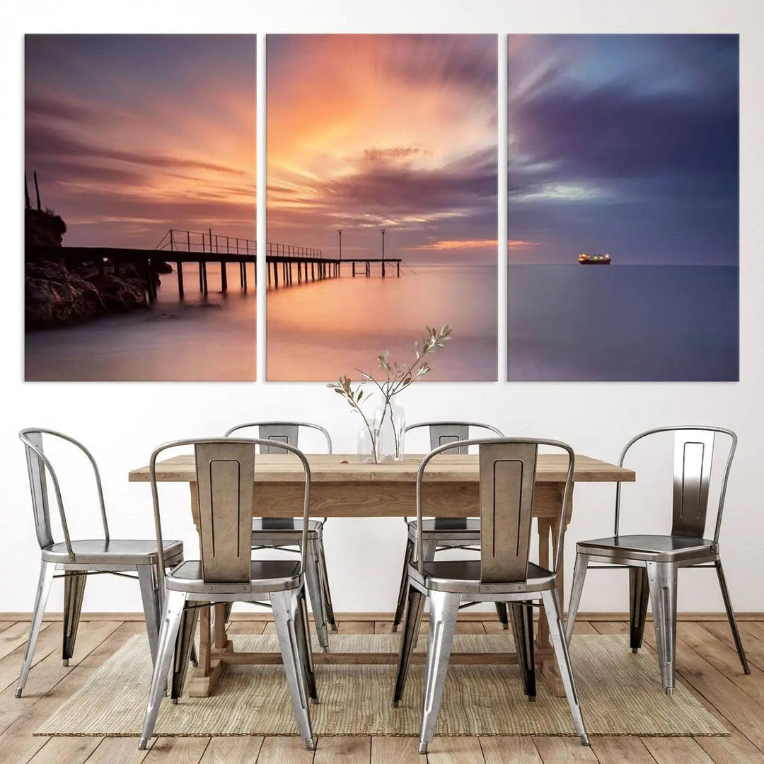 The Sunset Serenity Pier Canvas Art, a giclee canvas print with gallery wrap, beautifully captures a triptych of tranquility as the sun sets over calm waters. Featuring a pier on the left and a ship on the horizon, it adds an elegant touch to any living space with its serene coastal decor.