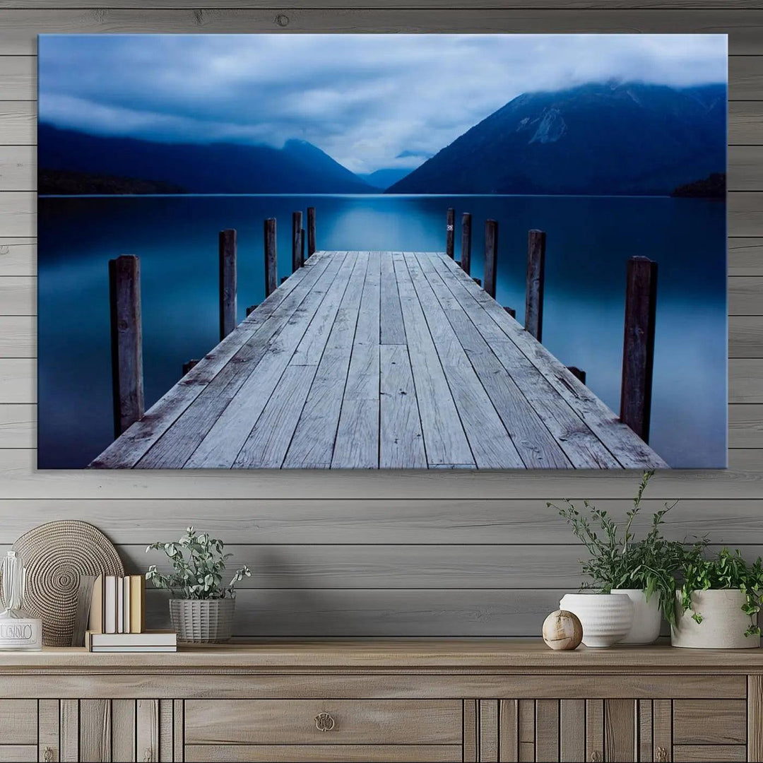 Tranquil lakeside pier triptych canvas art featuring a blue mountain horizon and serene dock. Perfect for modern interiors. High-quality giclee canvas print.