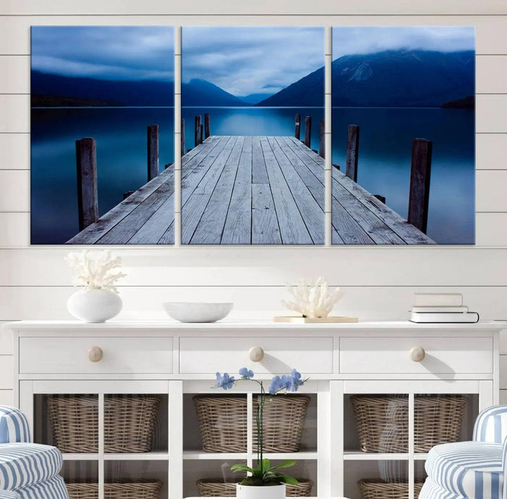 Tranquil lakeside pier triptych canvas art featuring a blue mountain horizon and serene dock. Perfect for modern interiors. High-quality giclee canvas print.