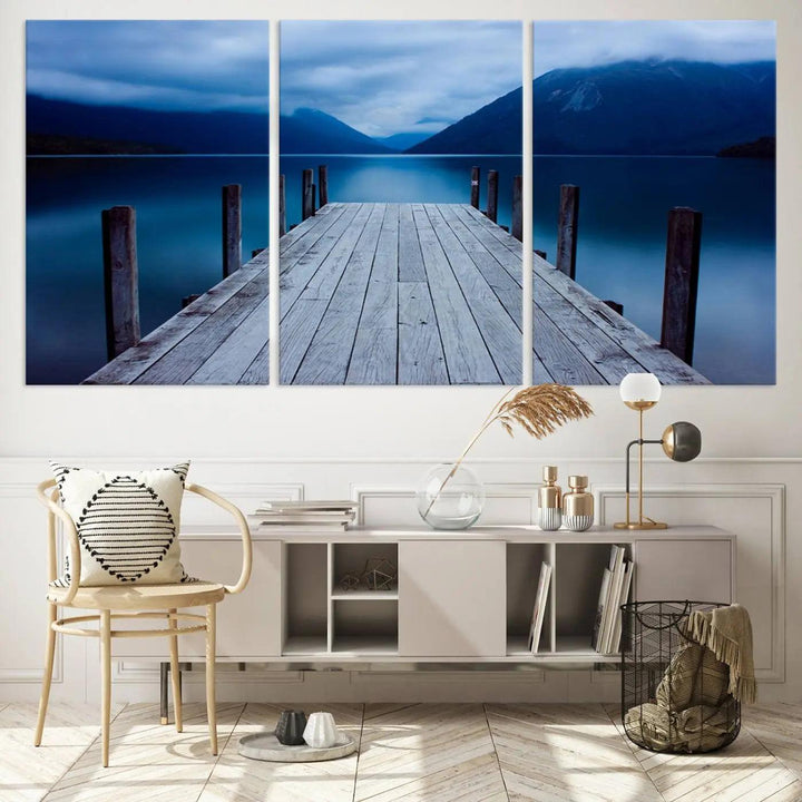 Tranquil lakeside pier triptych canvas art featuring a blue mountain horizon and serene dock. Perfect for modern interiors. High-quality giclee canvas print.