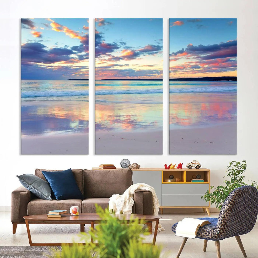 A modern living room is accentuated by a stunning Tranquil Pastel Sunset Beach Triptych Canvas Art on the wall, epitomizing coastal home decor elegance.