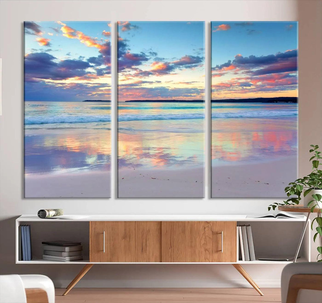 A modern living room is accentuated by a stunning Tranquil Pastel Sunset Beach Triptych Canvas Art on the wall, epitomizing coastal home decor elegance.