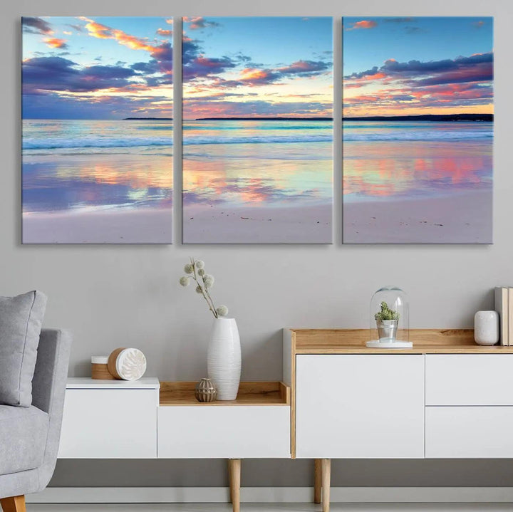 A modern living room is accentuated by a stunning Tranquil Pastel Sunset Beach Triptych Canvas Art on the wall, epitomizing coastal home decor elegance.