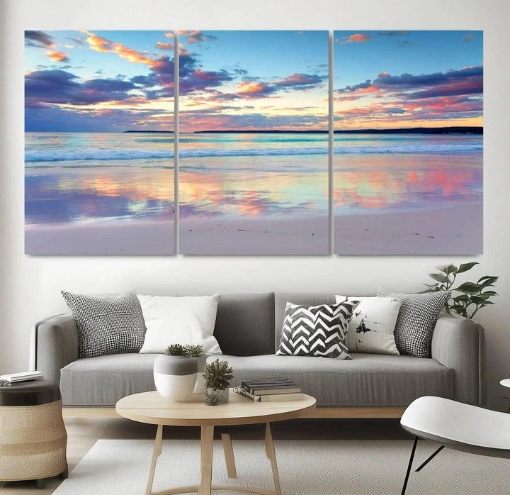 A modern living room is accentuated by a stunning Tranquil Pastel Sunset Beach Triptych Canvas Art on the wall, epitomizing coastal home decor elegance.