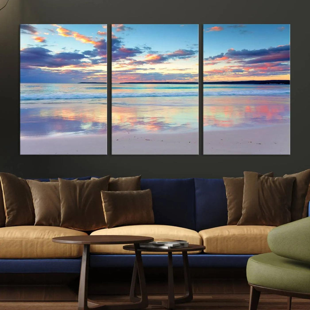 A modern living room is accentuated by a stunning Tranquil Pastel Sunset Beach Triptych Canvas Art on the wall, epitomizing coastal home decor elegance.