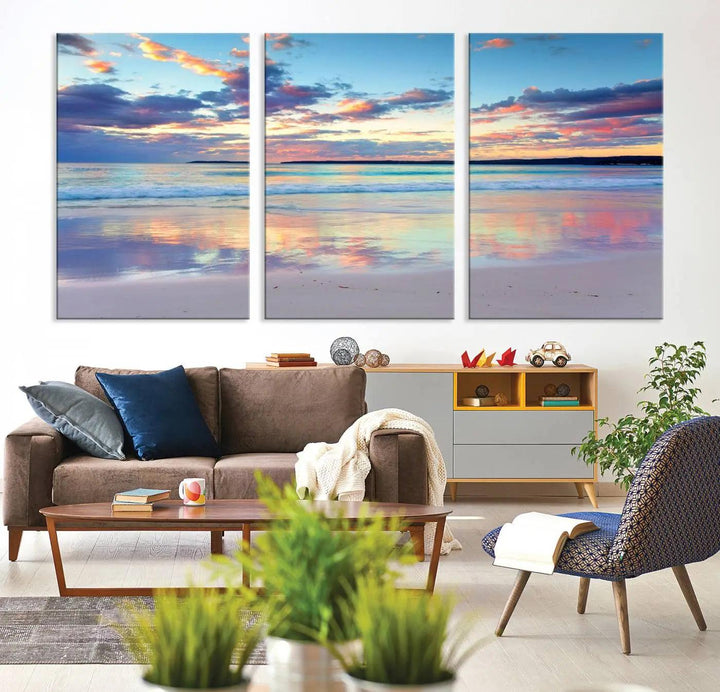 A modern living room is accentuated by a stunning Tranquil Pastel Sunset Beach Triptych Canvas Art on the wall, epitomizing coastal home decor elegance.