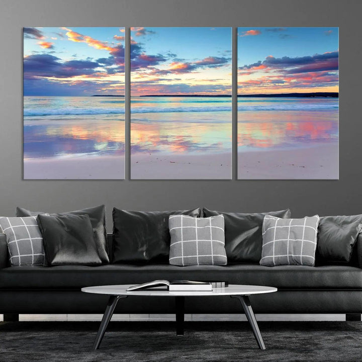 A modern living room is accentuated by a stunning Tranquil Pastel Sunset Beach Triptych Canvas Art on the wall, epitomizing coastal home decor elegance.