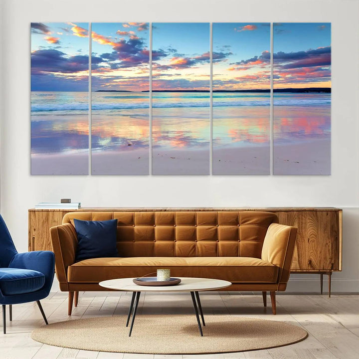 A modern living room is accentuated by a stunning Tranquil Pastel Sunset Beach Triptych Canvas Art on the wall, epitomizing coastal home decor elegance.