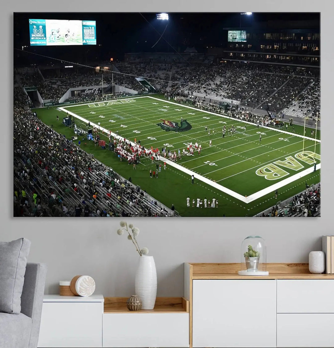 A dining area showcasing a gallery-quality triptych of the UAB Blazers Football Team Print at Birmingham Protective Stadium adorns the wall.