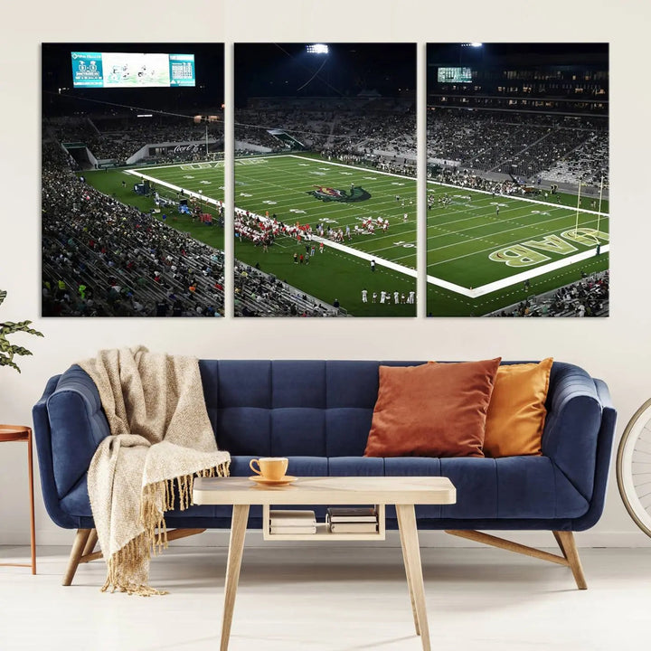 A dining area showcasing a gallery-quality triptych of the UAB Blazers Football Team Print at Birmingham Protective Stadium adorns the wall.