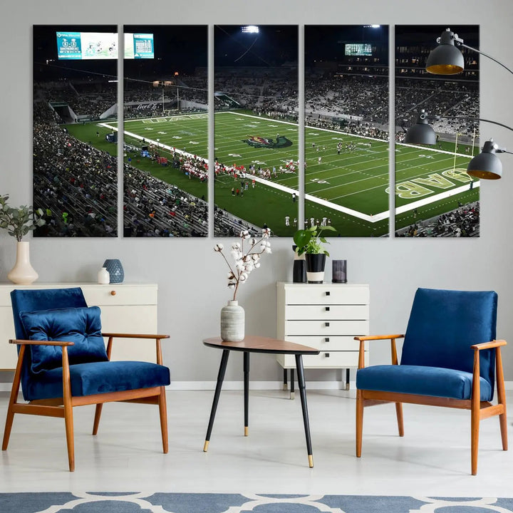 A dining area showcasing a gallery-quality triptych of the UAB Blazers Football Team Print at Birmingham Protective Stadium adorns the wall.