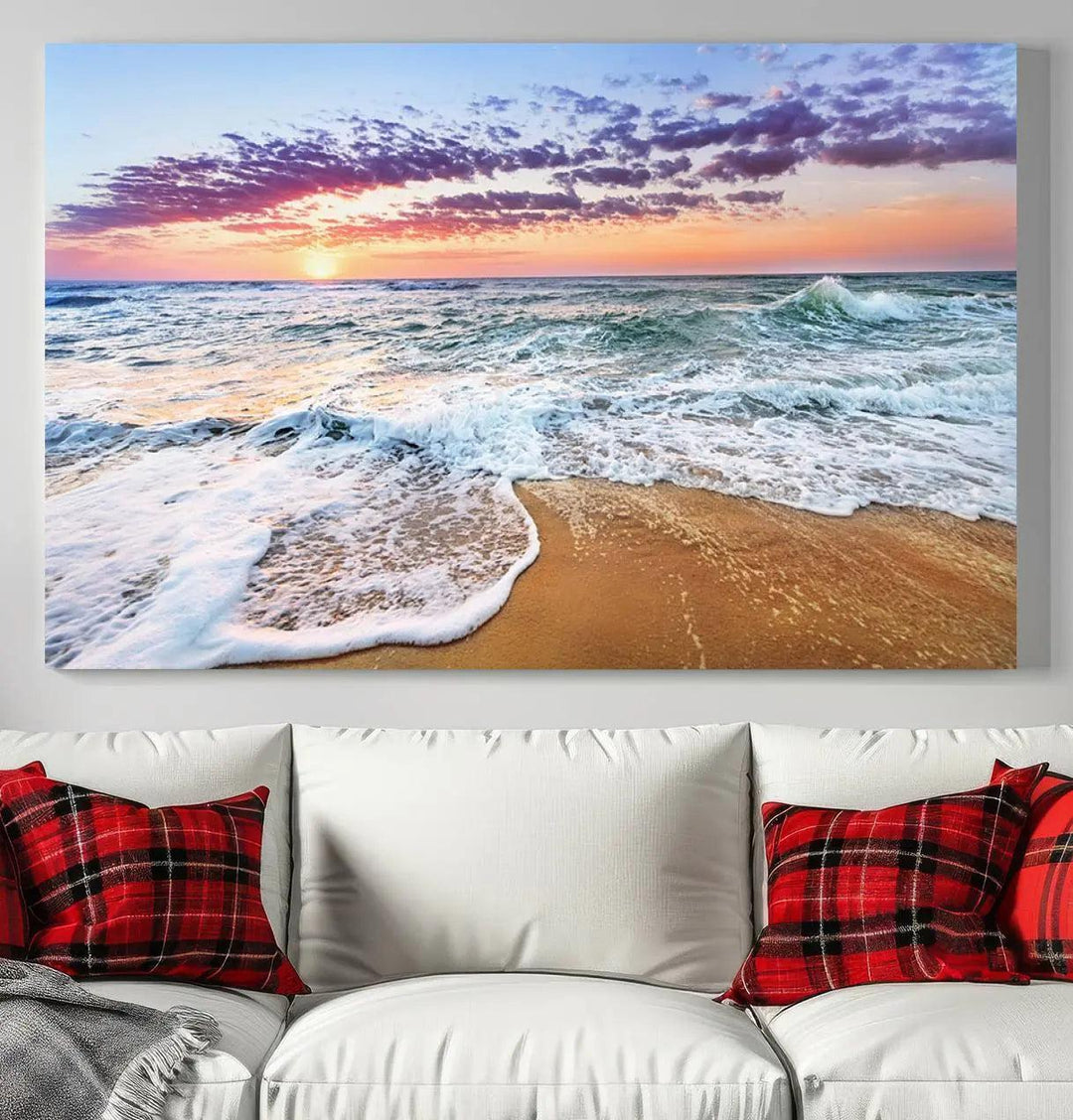 The "Vivid Sunset Ocean Waves Wall Art" hangs on the wall, capturing the serene beauty of the sea. This coastal beach canvas print triptych perfectly enhances living rooms and relaxation spaces.