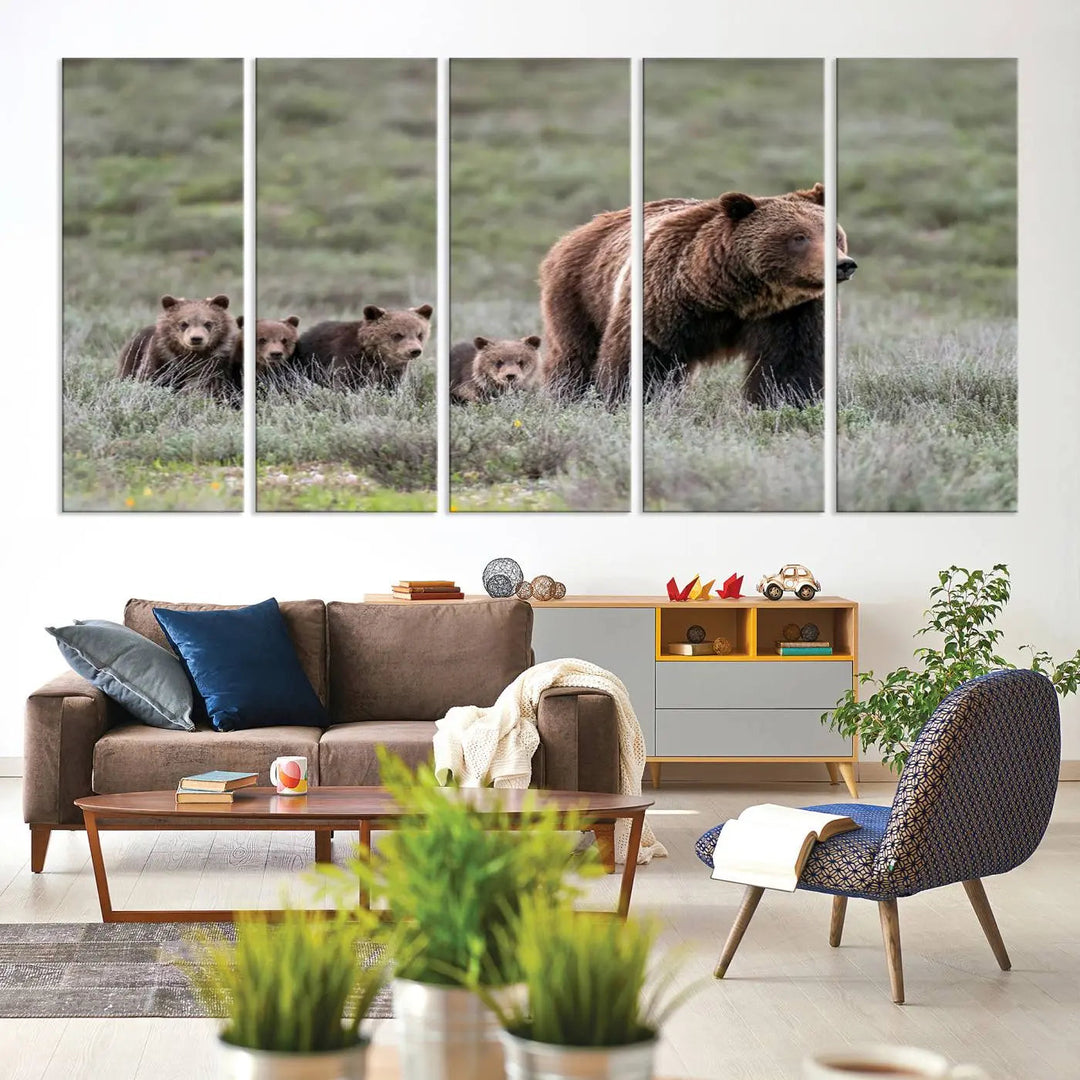 The canvas wall art print, titled "Queen of the Tetons," features a photo of 399 grizzly bear cubs walking with a larger bear in a green, open field. This striking piece is framed and leaning against a wall, showcasing its gallery-quality finish.