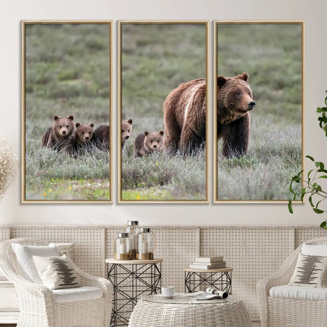 The canvas wall art print, titled "Queen of the Tetons," features a photo of 399 grizzly bear cubs walking with a larger bear in a green, open field. This striking piece is framed and leaning against a wall, showcasing its gallery-quality finish.