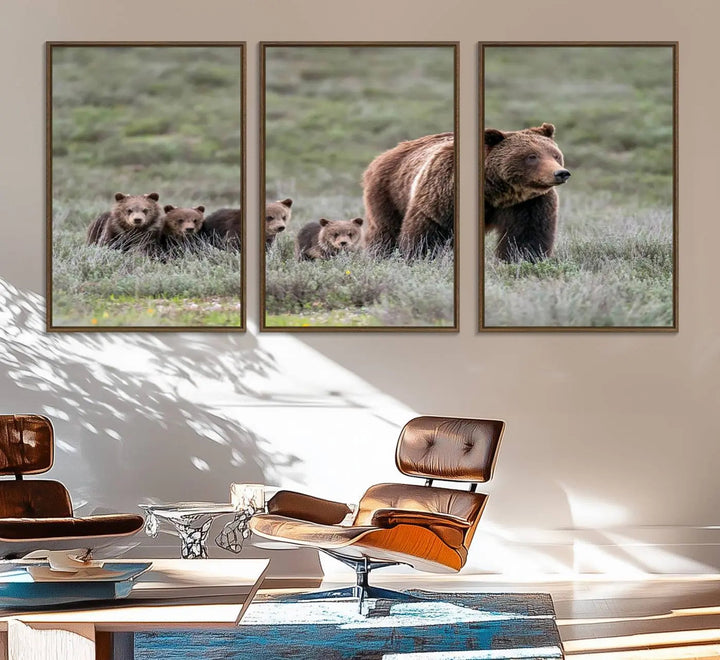 The canvas wall art print, titled "Queen of the Tetons," features a photo of 399 grizzly bear cubs walking with a larger bear in a green, open field. This striking piece is framed and leaning against a wall, showcasing its gallery-quality finish.