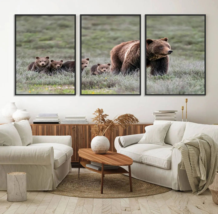 The canvas wall art print, titled "Queen of the Tetons," features a photo of 399 grizzly bear cubs walking with a larger bear in a green, open field. This striking piece is framed and leaning against a wall, showcasing its gallery-quality finish.