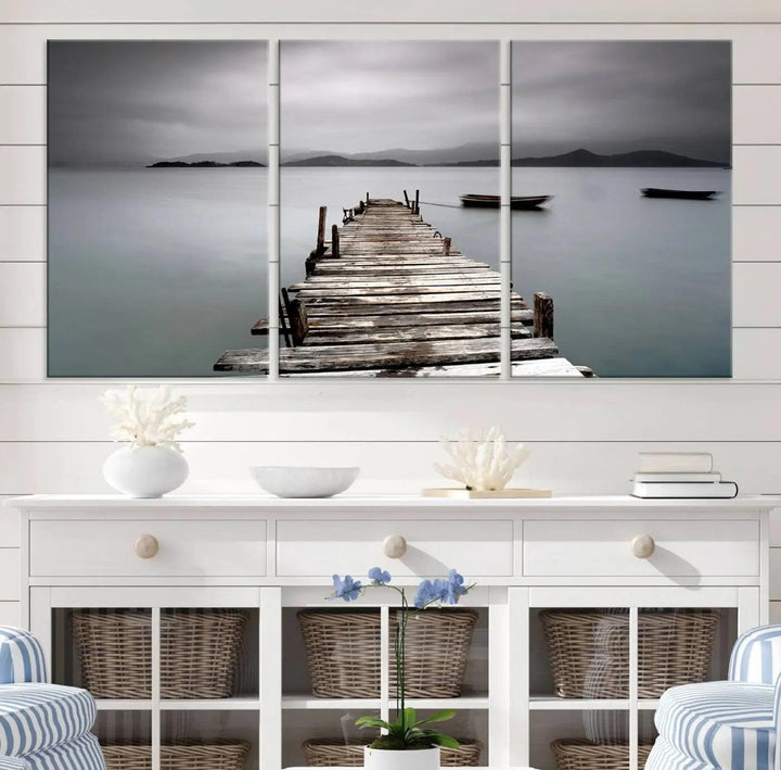 A serene triptych featuring a wooden pier stretching into misty waters brings the Wooden Pier Canvas Wall Art Beach Canvas Artwork Print to life.