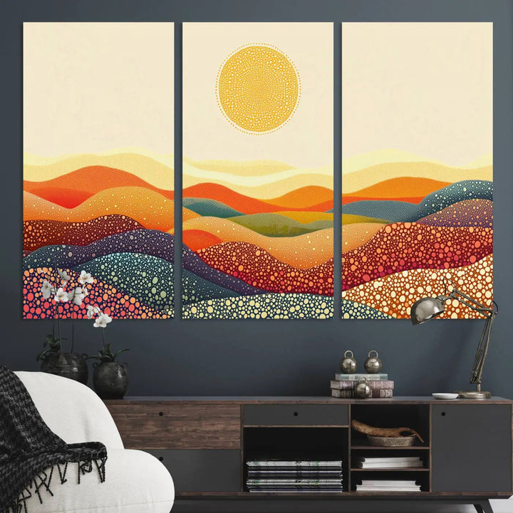 A triptych featuring the YAYOI KUSAMA Colorful Dot Art Landscape Canvas showcases a vibrant abstract pointillism design with rolling hills and a sun. It's mounted on premium canvas and displayed on a dark wall.