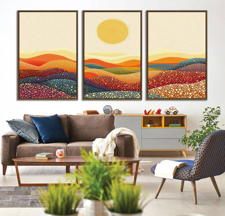 A triptych featuring the YAYOI KUSAMA Colorful Dot Art Landscape Canvas showcases a vibrant abstract pointillism design with rolling hills and a sun. It's mounted on premium canvas and displayed on a dark wall.