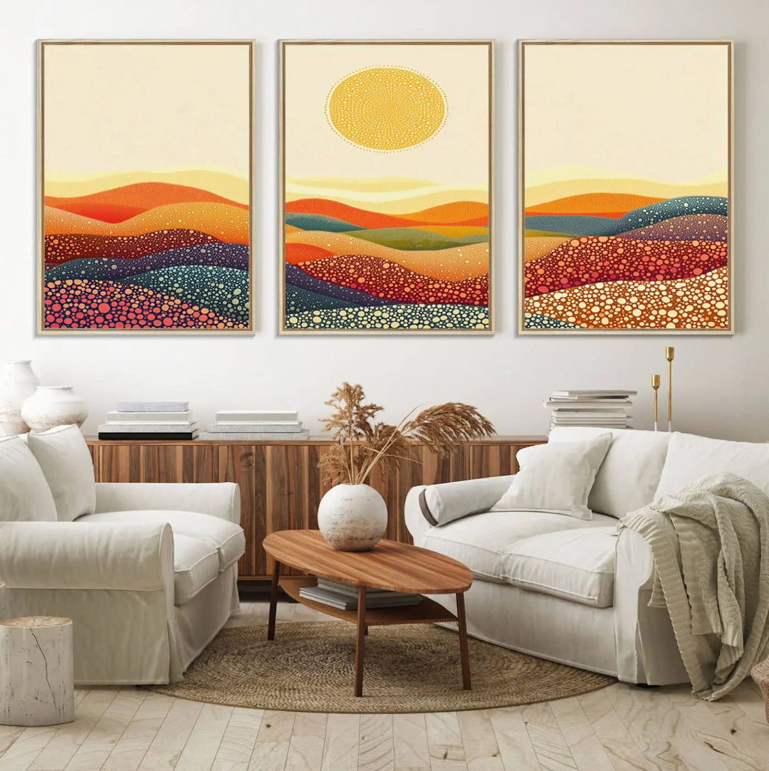 A triptych featuring the YAYOI KUSAMA Colorful Dot Art Landscape Canvas showcases a vibrant abstract pointillism design with rolling hills and a sun. It's mounted on premium canvas and displayed on a dark wall.