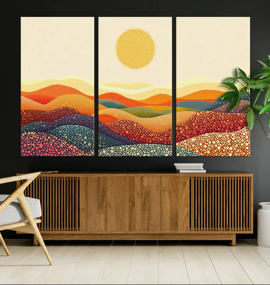 A triptych featuring the YAYOI KUSAMA Colorful Dot Art Landscape Canvas showcases a vibrant abstract pointillism design with rolling hills and a sun. It's mounted on premium canvas and displayed on a dark wall.